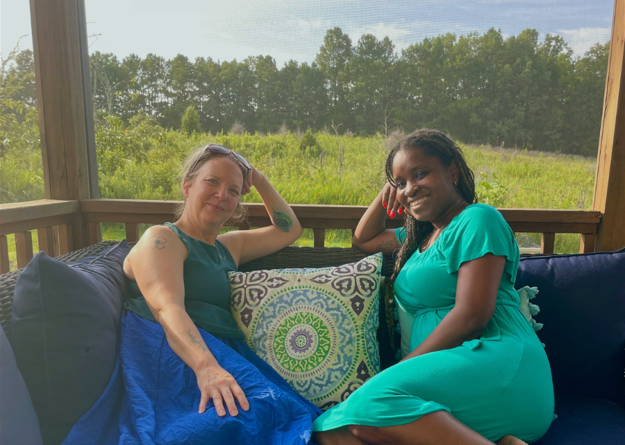 Co-founders, Karen and Tara sitting together outdoors, relaxed and smiling